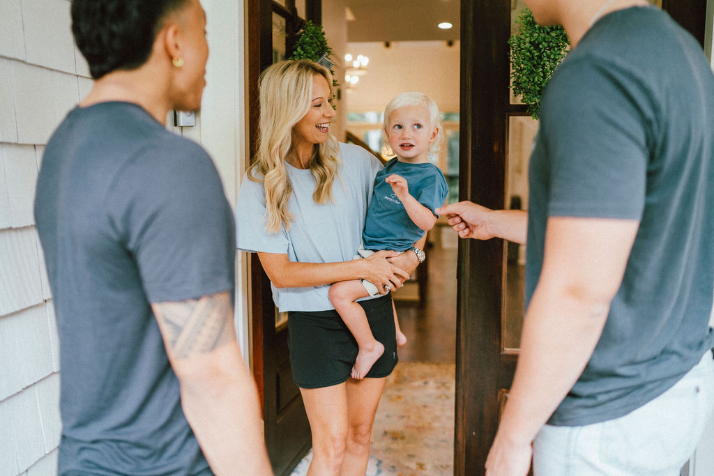 A homeowner greeting a service crew at her new home